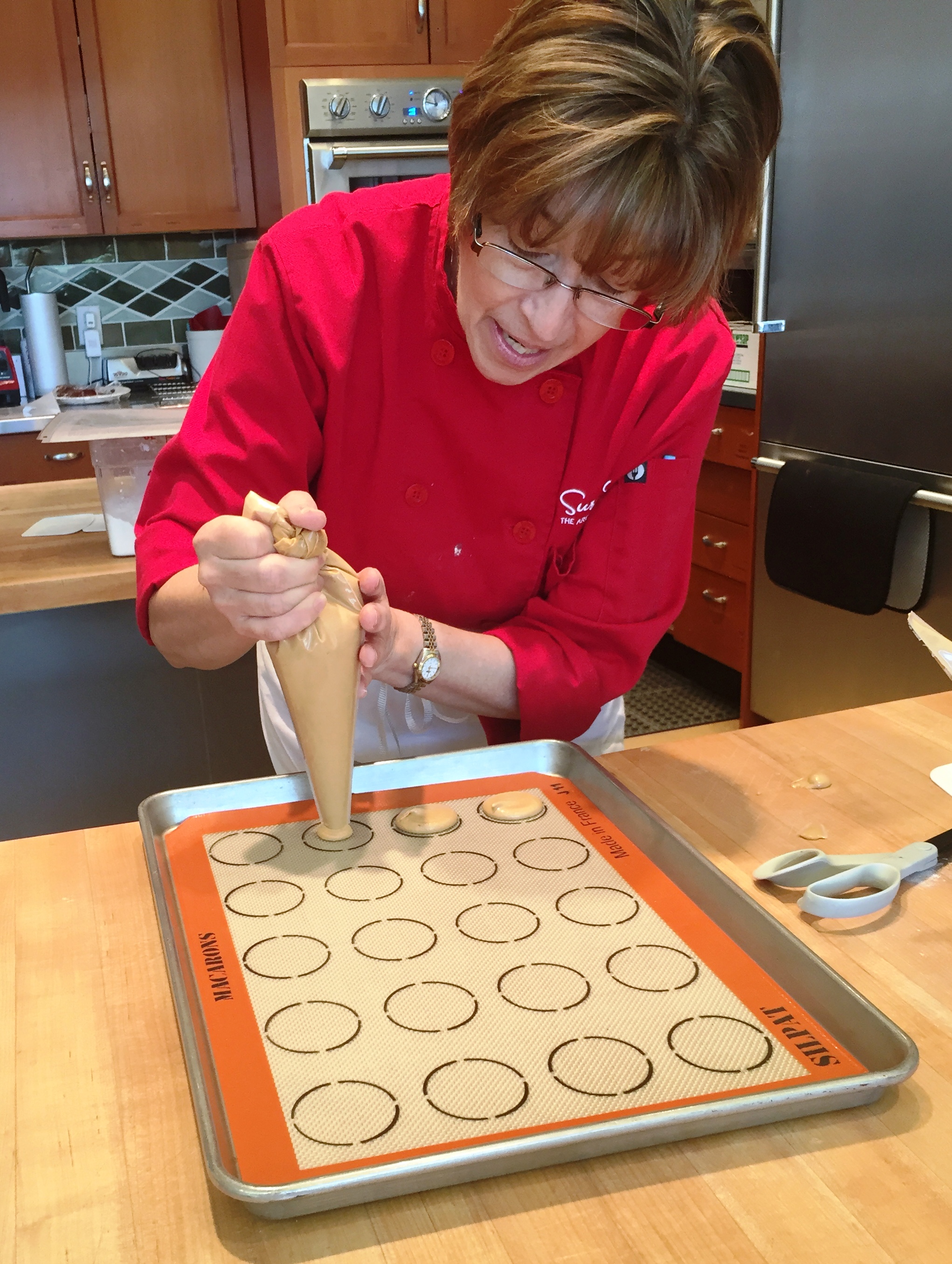 Batter being piped onto stenciled silpat.JPG